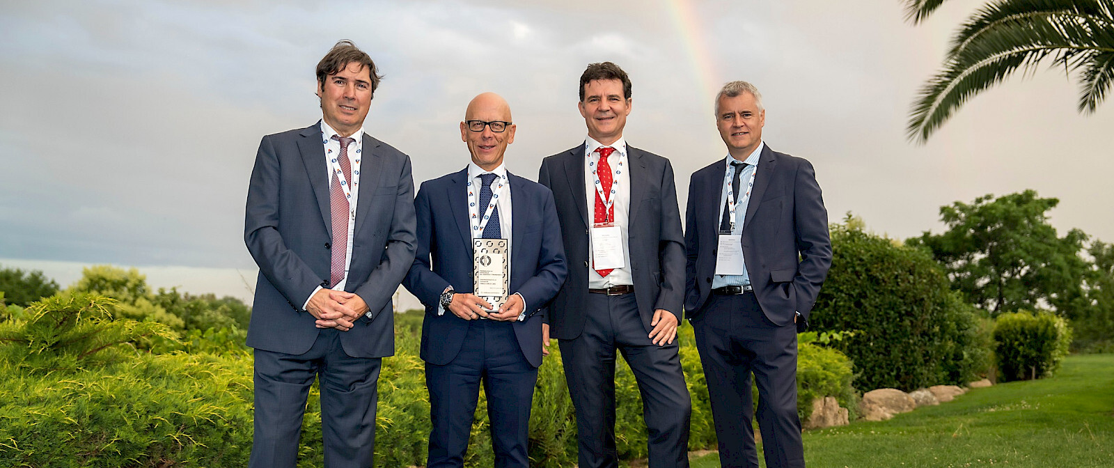 men standing holding award suit