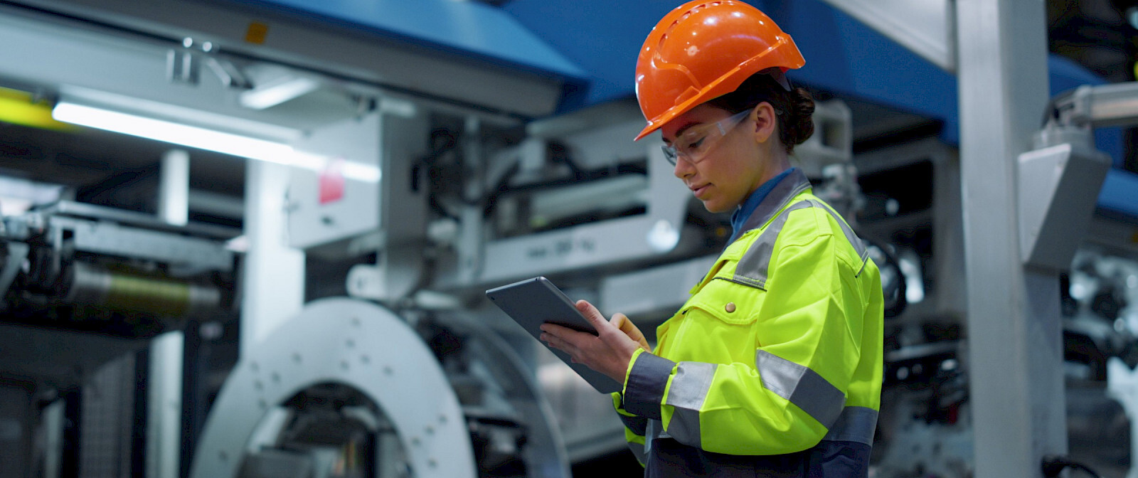woman working industrial holding tablet orange helmet