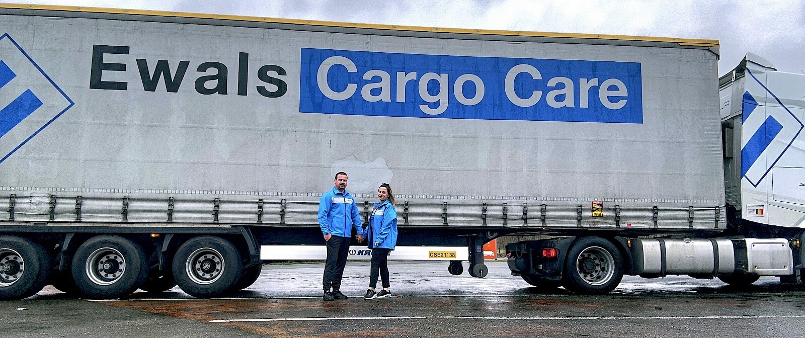 two employees standing in front of truck